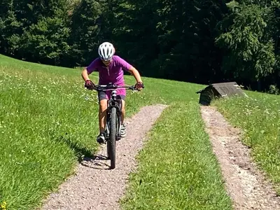 a person riding a bike down a trail at Hotel Garni Christin in Ora/Auer