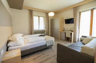 a large bedroom with a bed and a couch at Villa Vera in Ora/Auer