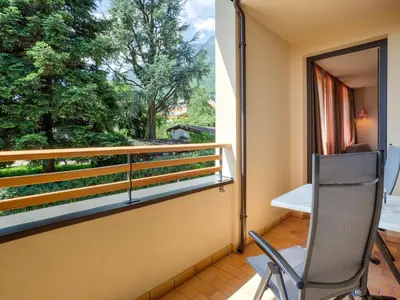 a chair sitting on a balcony with a window at Residence Sonneckhof in Caldaro