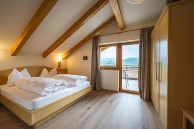 a bedroom with a bed and a large window at Residence Sonneckhof in Caldaro