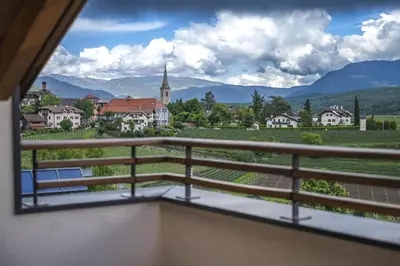 a balcony with a view of a town and mountains at Residence Sonneckhof in Caldaro