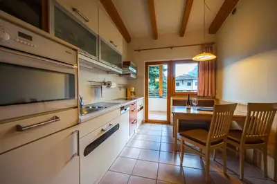 a kitchen with a table and a dining room at Residence Sonneckhof in Caldaro