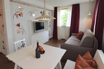 a living room with a white table and a couch at Residence Sonneckhof in Caldaro