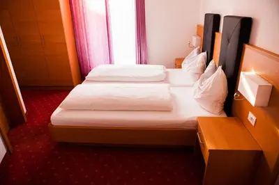 a hotel room with two beds and a window at Gasthaus Abram in Ora/Auer