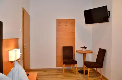 a room with two chairs and a table and a tv at Gasthaus Abram in Ora/Auer