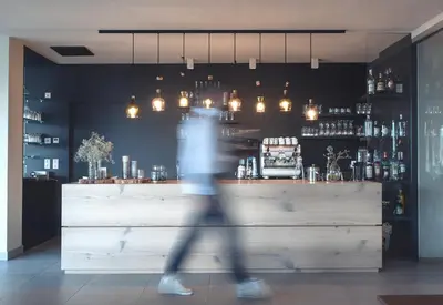a person walking in front of a bar at Das Wanda in Caldaro