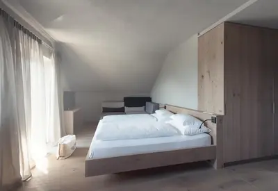 a bedroom with a bed and a large window at Das Wanda in Caldaro