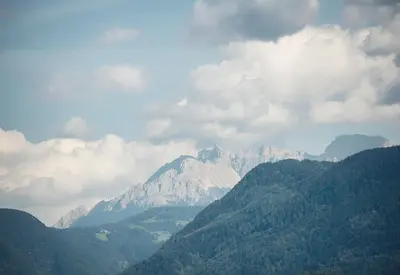 a kite flying in front of a mountain range at Das Wanda in Caldaro