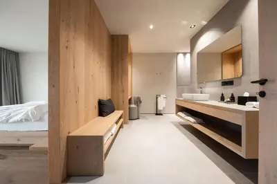 a large bathroom with a sink and a bed at Das Wanda in Caldaro
