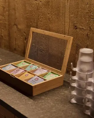 a wooden box sitting on a counter next to a stack of cups at Hotel Mesdi in Arabba