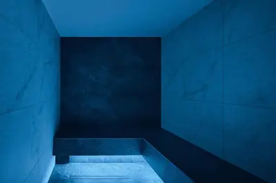 a blue bathroom with a bench in a room at Hotel Mesdi in Arabba