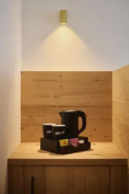 a black coffee mug sitting on a shelf under a light at Hotel Mesdi in Arabba