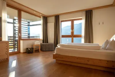 a living room with a couch and a chair at Hotel Fischer in Bressanone