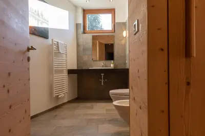 a bathroom with a white sink and a toilet at Hotel Fischer in Bressanone