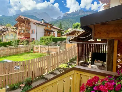 a house with a wooden fence and a backyard at Casa di Franz in Vigo di Fassa