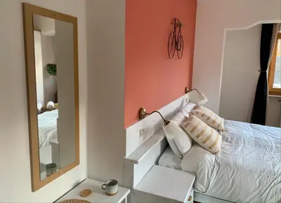 a bedroom with a white bed and a mirror at Casa di Franz in Vigo di Fassa