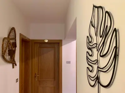 a hallway with a door with a painting on the wall at Casa di Franz in Vigo di Fassa
