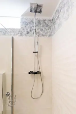 a shower with a hose hanging from the ceiling in a bathroom at Dolce Vista in Merano