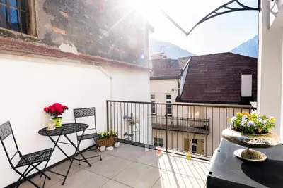 a balcony with a table and chairs on a building at Dolce Vista in Merano