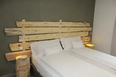 a bedroom with a bed with a wooden headboard at Chalet Margoni in Canazei