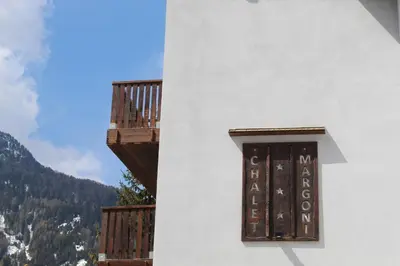 a white building with a window and a balcony at Chalet Margoni in Canazei