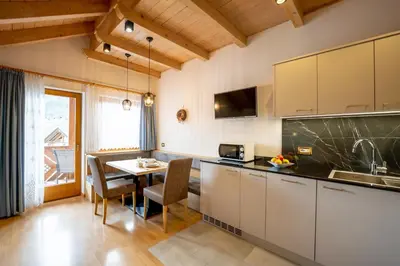 a kitchen with a table and a dining room at Apartments Lasteis in La Villa