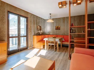 a bedroom with a bed and a dresser and a chair at Apartment Condominio al Parco-9 by Interhome in Canazei
