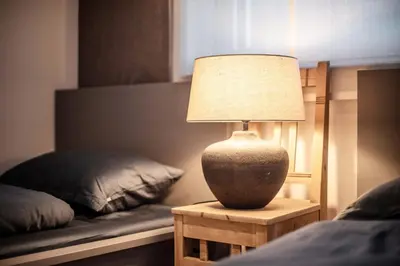 a lamp sitting on a table next to a bed at Apartment Schifta in Chienes