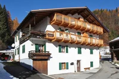 a large white building with wooden balconies on it at Casa Lisa in Falcade