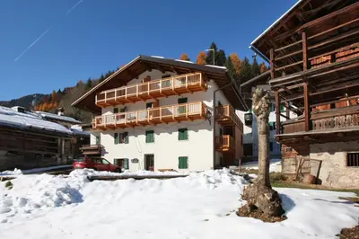 a house with a balcony in the snow at Casa Lisa in Falcade