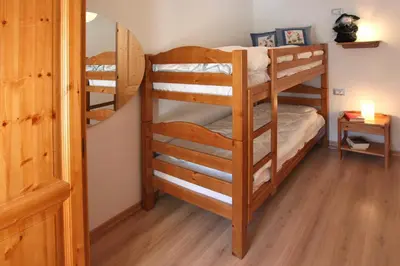 a room with two bunk beds and a mirror at Casa Lisa in Falcade
