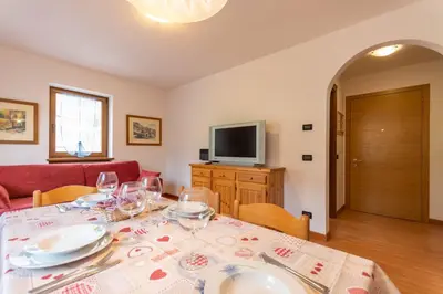 a dining room with a table with wine glasses at Casa NeveXenne & La Casa di Blek in Alleghe