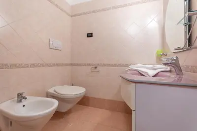 a bathroom with a white toilet and a sink at Casa NeveXenne & La Casa di Blek in Alleghe