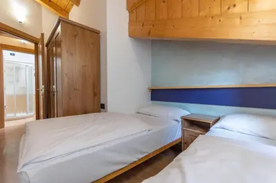 two beds in a small room with aermottermottermottermott at Casa NeveXenne & La Casa di Blek in Alleghe
