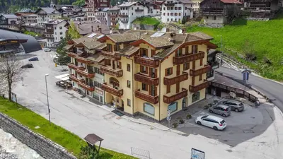 an overhead view of a large yellow building with a parking lot at Casa NeveXenne & La Casa di Blek in Alleghe