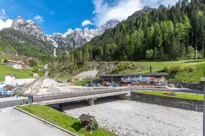 a bridge over a river next to a mountain at Casa NeveXenne & La Casa di Blek in Alleghe