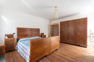 a bedroom with a large bed and wooden cabinets at Cesa al Monech in Selva di Cadore
