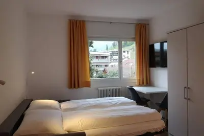 a bedroom with two beds and a desk and a window at Appartment Barbara in Bolzano