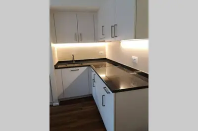 an empty kitchen with white cabinets and a sink at Appartment Barbara in Bolzano