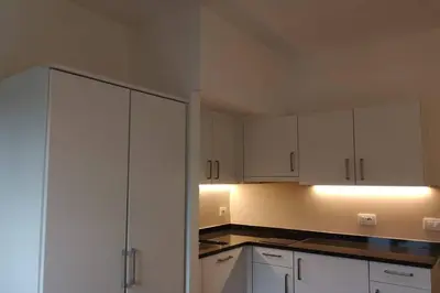 a kitchen with white cabinets and black counter tops at Appartment Barbara in Bolzano