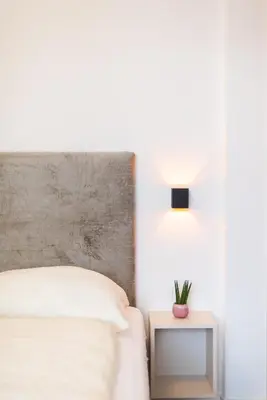 a bedroom with a bed and a table with a lamp at CityPointApartments- Theatre in Merano