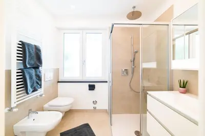 a bathroom with a shower and a toilet and a sink at CityPointApartments- Theatre in Merano