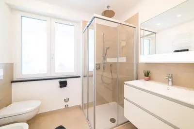 a bathroom with a shower and a toilet and a sink at CityPointApartments- Theatre in Merano