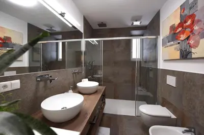 a bathroom with two sinks and a shower at CityChalet romantic Bozen in Bolzano