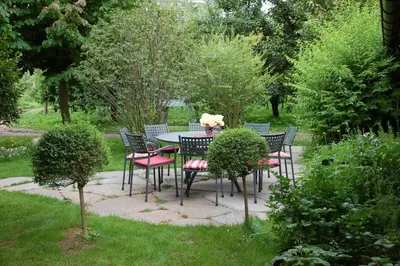 a table and chairs in a garden with flowers on it at Callhof - Bio Obsthof in Lana