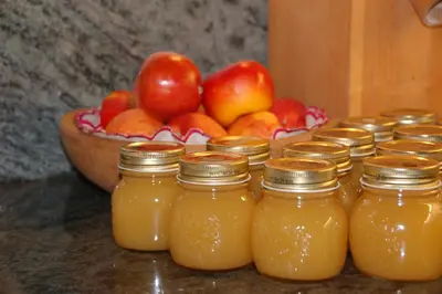 a group of jars of apple juice with a bowl of apples at Callhof - Bio Obsthof in Lana