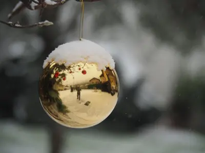 a reflection of a person in a ball of snow at Ferienwohnungen Luggin in Caldaro