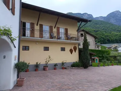 a building with a balcony and potted plants at Ferienwohnungen Luggin in Caldaro