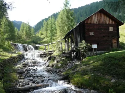 a train station next to a river next to a waterfall at L'GROF - AL CONTE in San Martino in Badia