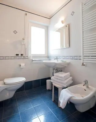 a white bathroom with a sink and a toilet at L'GROF - AL CONTE in San Martino in Badia